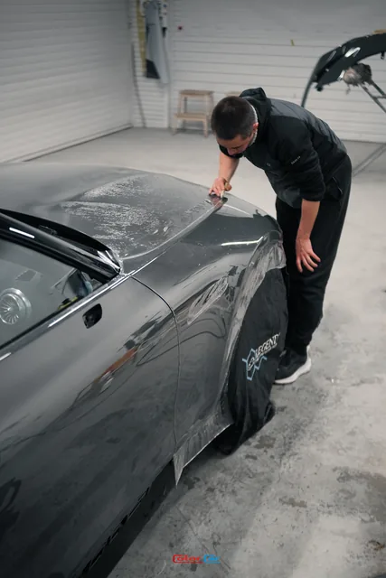 Мастер наносит прозрачную плёнку на капот Mercedes SL, кадр 4