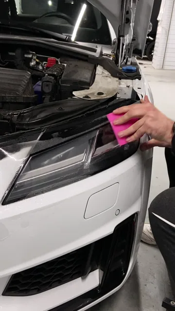 Кадр из видео Color Car: разглаживание полиуретановой плёнки розовым ракелем на передней фаре Audi TT, кадр 3