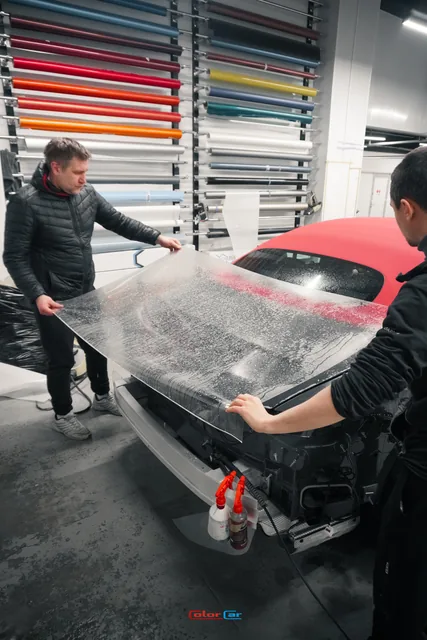 Два мастера укладывают прозрачную плёнку на заднюю часть Mercedes SL, кадр 13